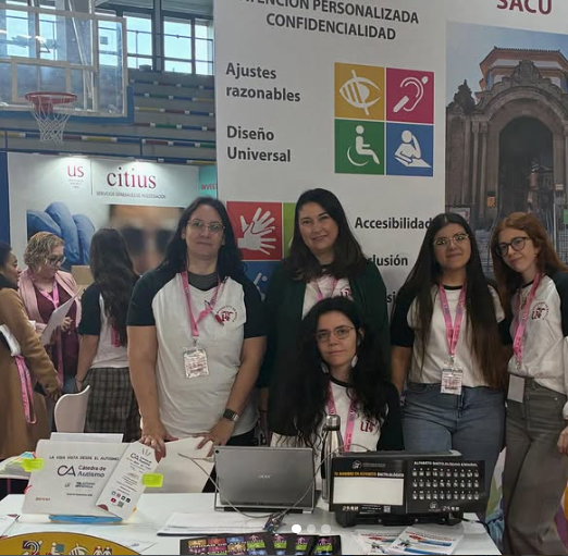 Equipo de profesionales de la unidad de atención a estudiantes con discapacidad y de la Cátedra de Autismo frente al stand de Discapacidad